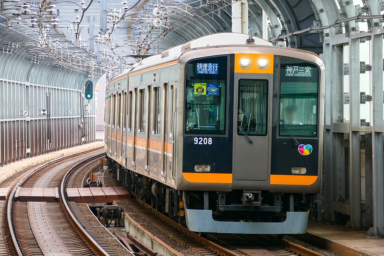 A 9000 series 9208 rapid express bound for Kobe-Sannomiya enters Nishikujo Station on the Hanshin Namba Line.