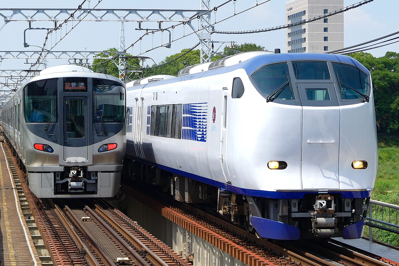 A JR West 225 series 5100 and a 281 series Haruka limited express running near Asaka Station on the Hanwa Line.