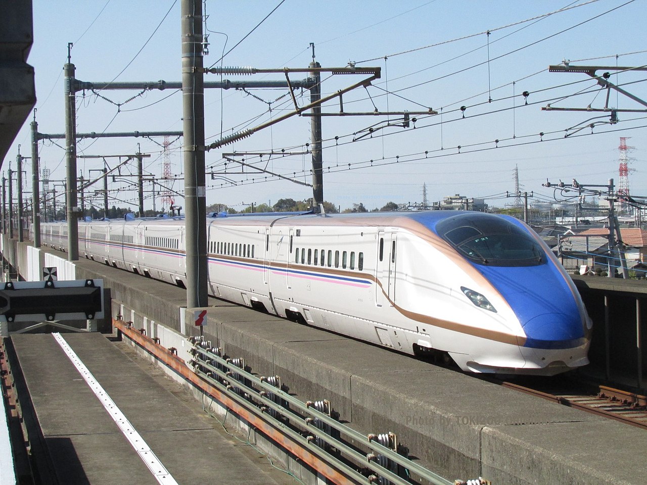 An E7 series set F21 in its Jōetsu Shinkansen special livery running between Kumagaya and Ōmiya.