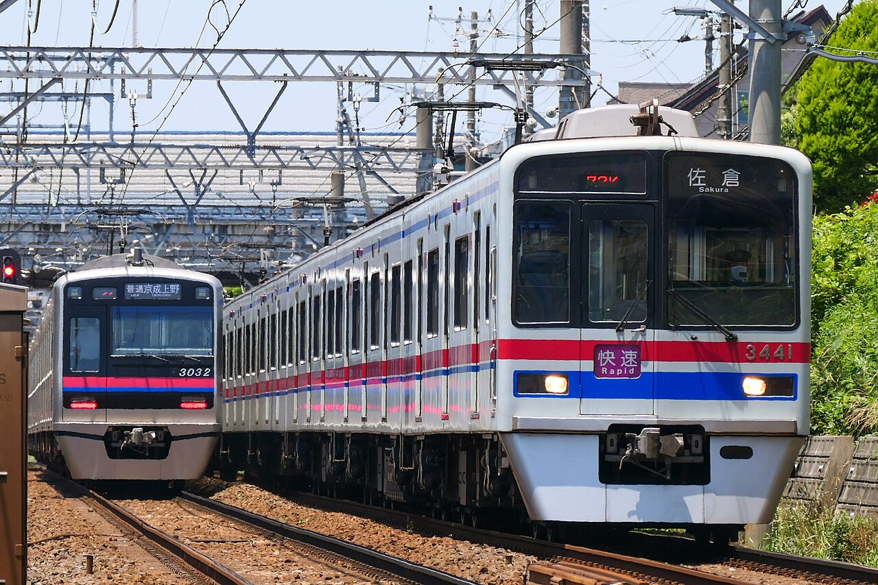 A Keisei 3400 series rapid and a 3000 series local passing between Funabashi-Keibajō and Yatsu on the Keisei Main Line.