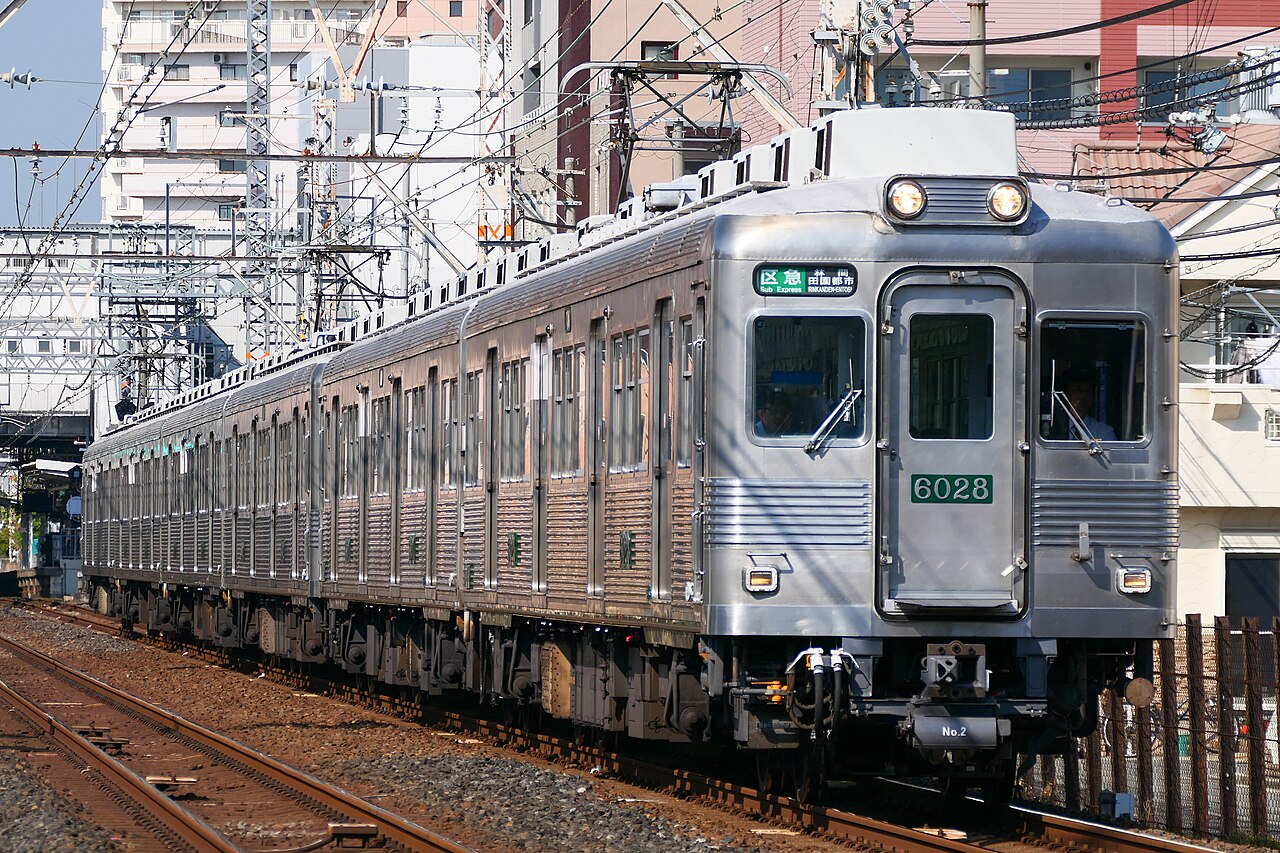 An unpainted stainless-steel Nankai 6000 series on a section express, running on the Nankai Kōya Line.