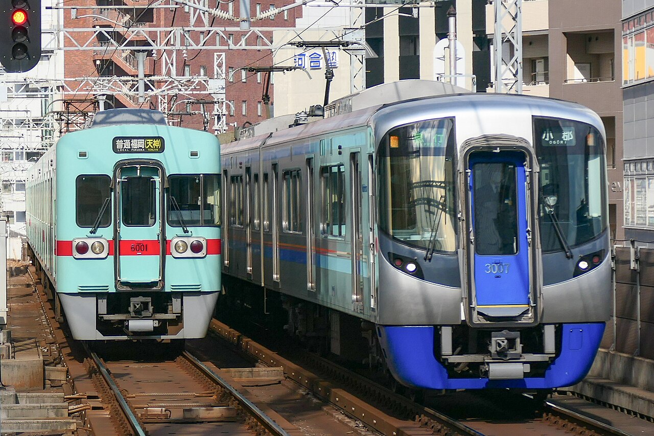 A 3000 series express and a 6000 series train between Nishitetsu Fukuoka (Tenjin) and Yakuin stations on the Tenjin Ōmuta Line.