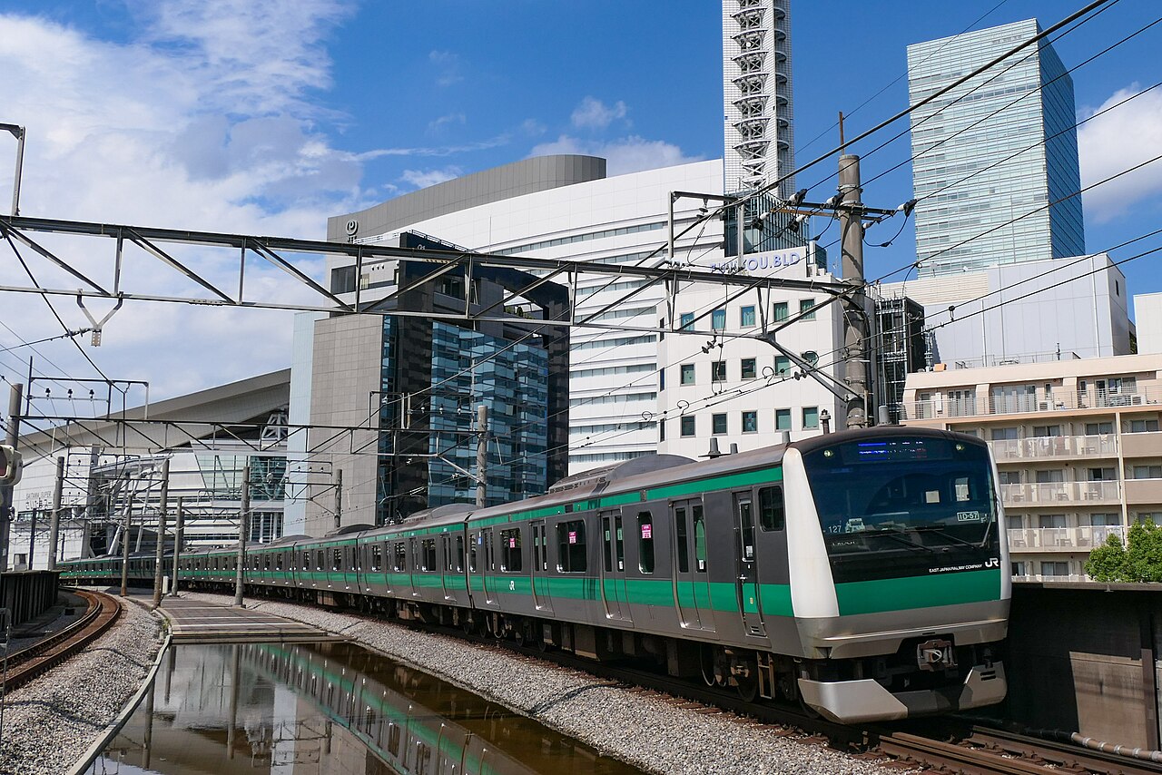 A JR East E233-7000 series set 127 entering Kita-Yono Station on the Saikyō Line, with the Saitama skyline behind.